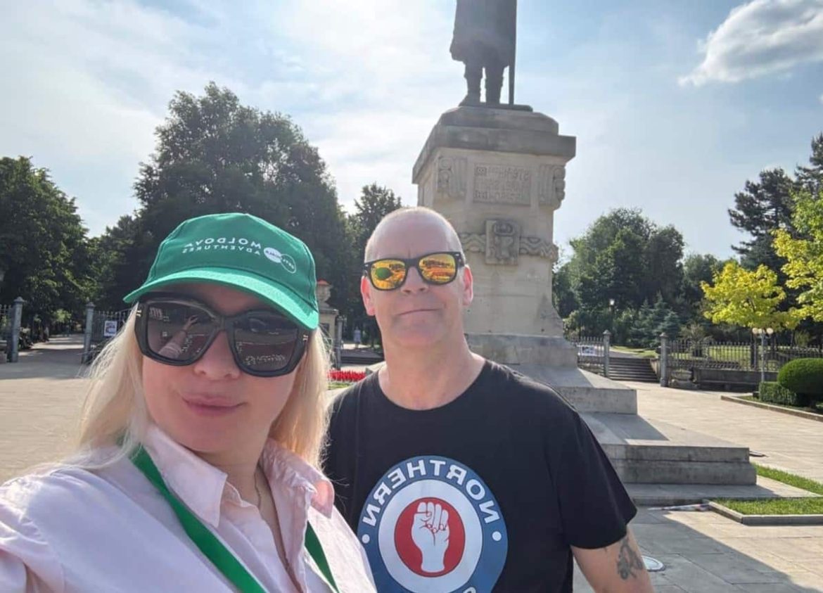 A smiling couple posing for a selfie in front of a historic monument in Chisinau while exploring the country on one of their Moldova tours.
